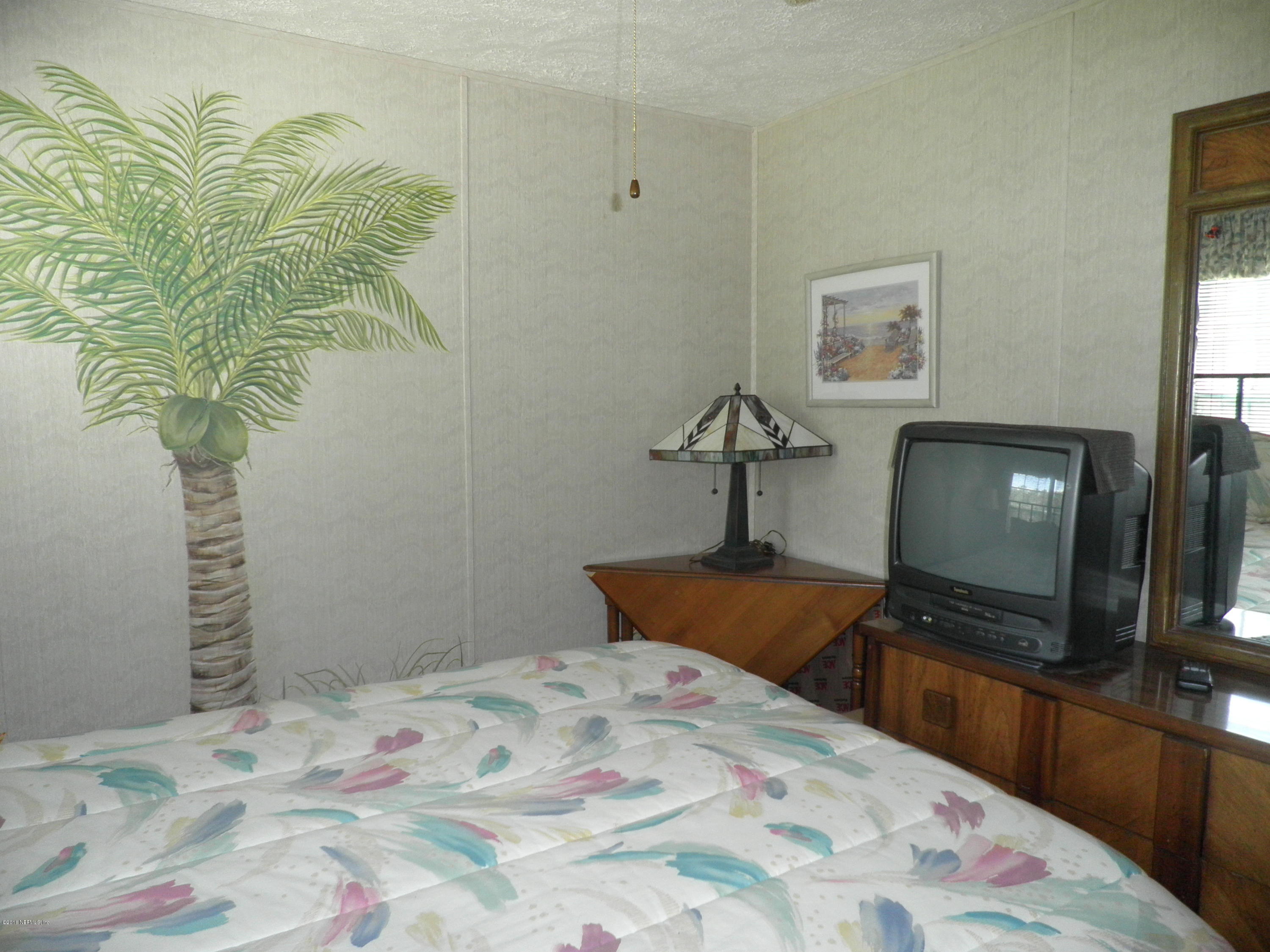 268 Beulah Church Road Welaka, FL 32112 - Photo 24 of 33 a bedroom with a bed and a potted plant