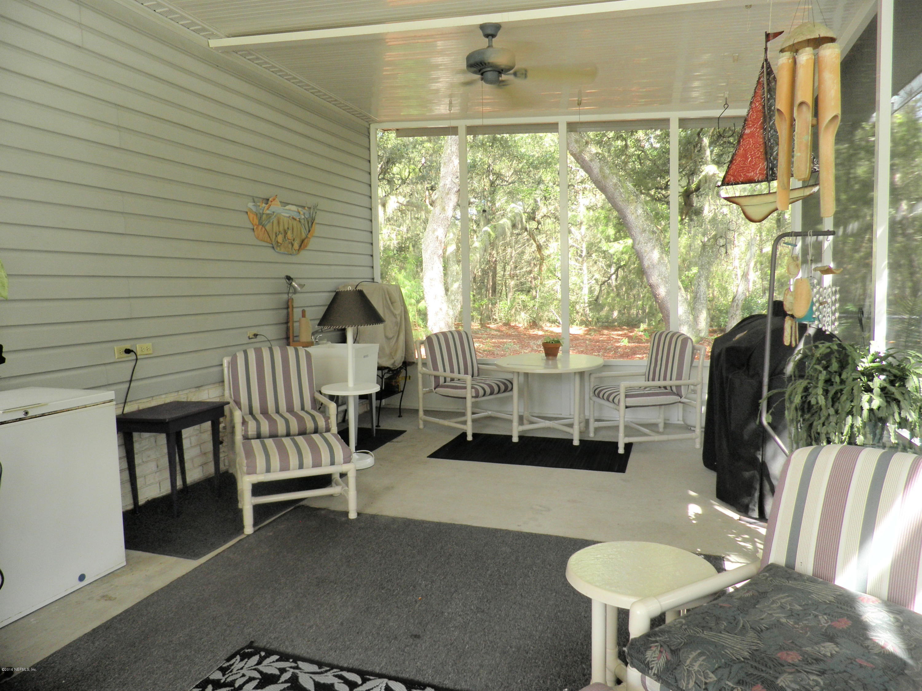 268 Beulah Church Road Welaka, FL 32112 - Photo 27 of 33 a dining room with furniture and a floor to ceiling window