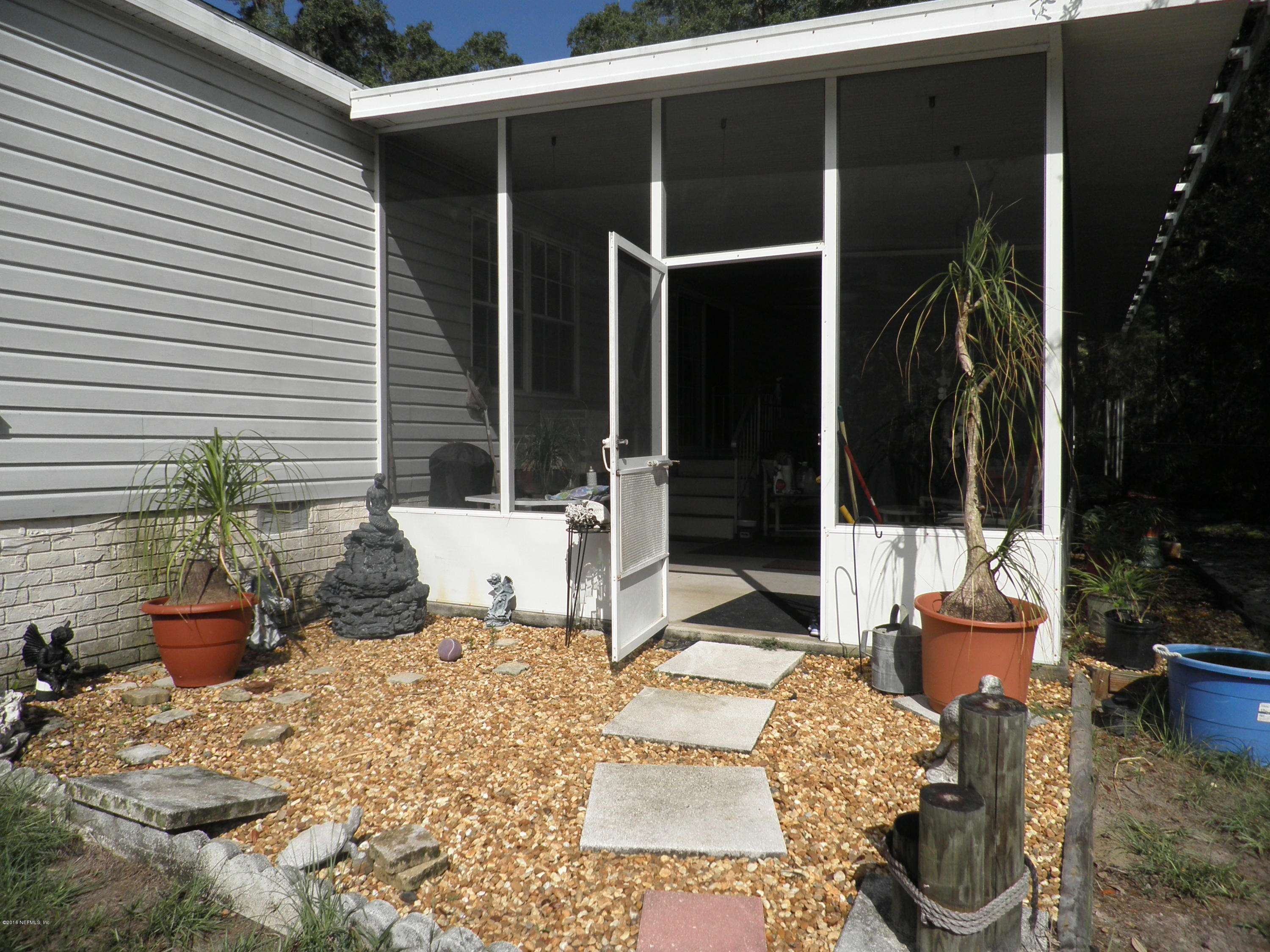 268 Beulah Church Road Welaka, FL 32112 - Photo 29 of 33 a view of a patio with couches chairs and potted plants