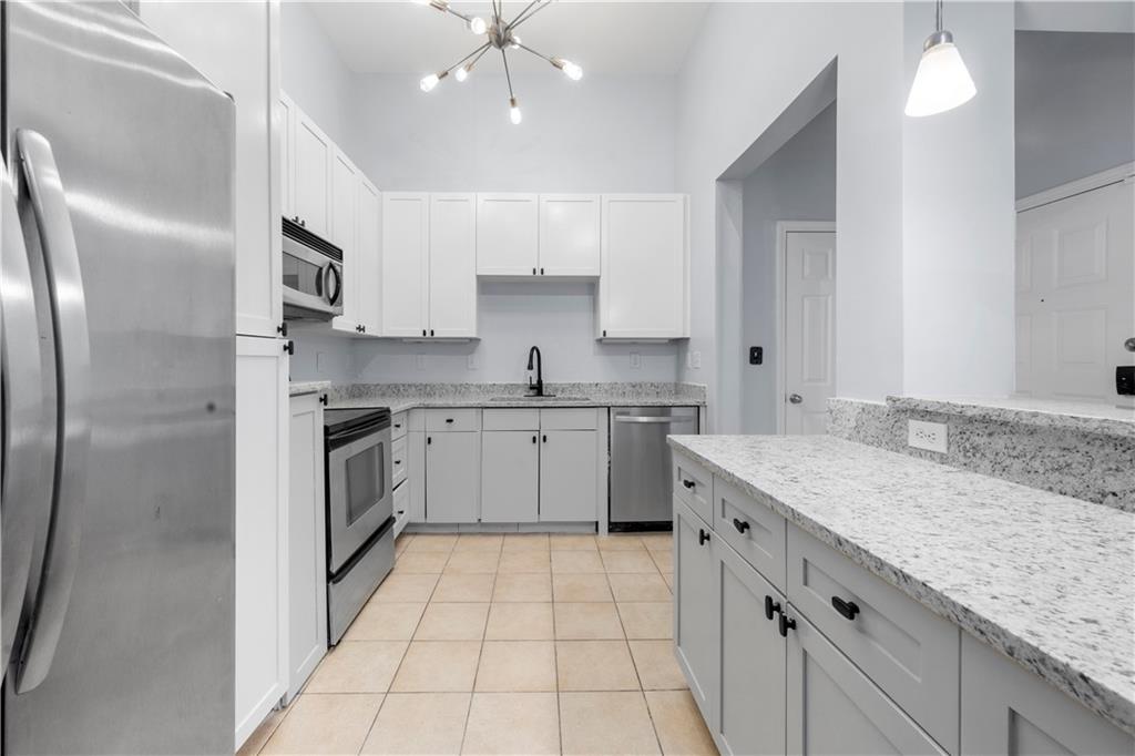 400 17th Street Northwest, Unit 1113 Atlanta, GA 30363 - Photo 11 of 37 a kitchen with a sink a stove a refrigerator and white cabinets
