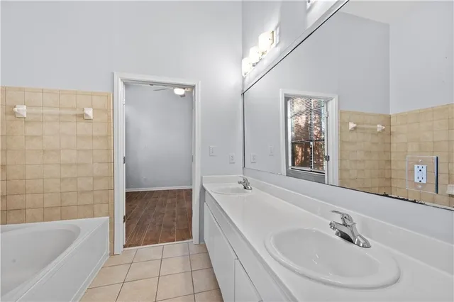 a bathroom with a bathtub shower sink and mirror