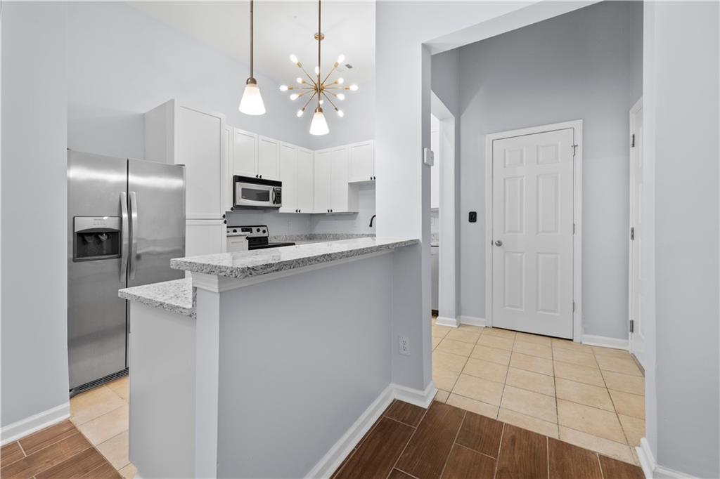 400 17th Street Northwest, Unit 1113 Atlanta, GA 30363 - Photo 8 of 37 a kitchen with kitchen island granite countertop stainless steel appliances a sink stove and refrigerator