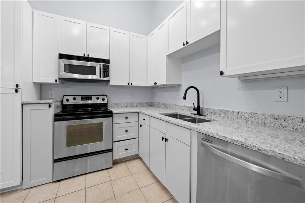 400 17th Street Northwest, Unit 1113 Atlanta, GA 30363 - Photo 10 of 37 a kitchen with granite countertop white cabinets stainless steel appliances and a sink