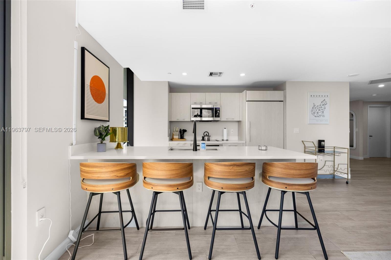 45 Southwest 9th Street, Unit 2803 Miami, FL 33130 - Photo 12 of 66 a dining hall with stainless steel appliances kitchen island granite countertop a dining table chairs and window