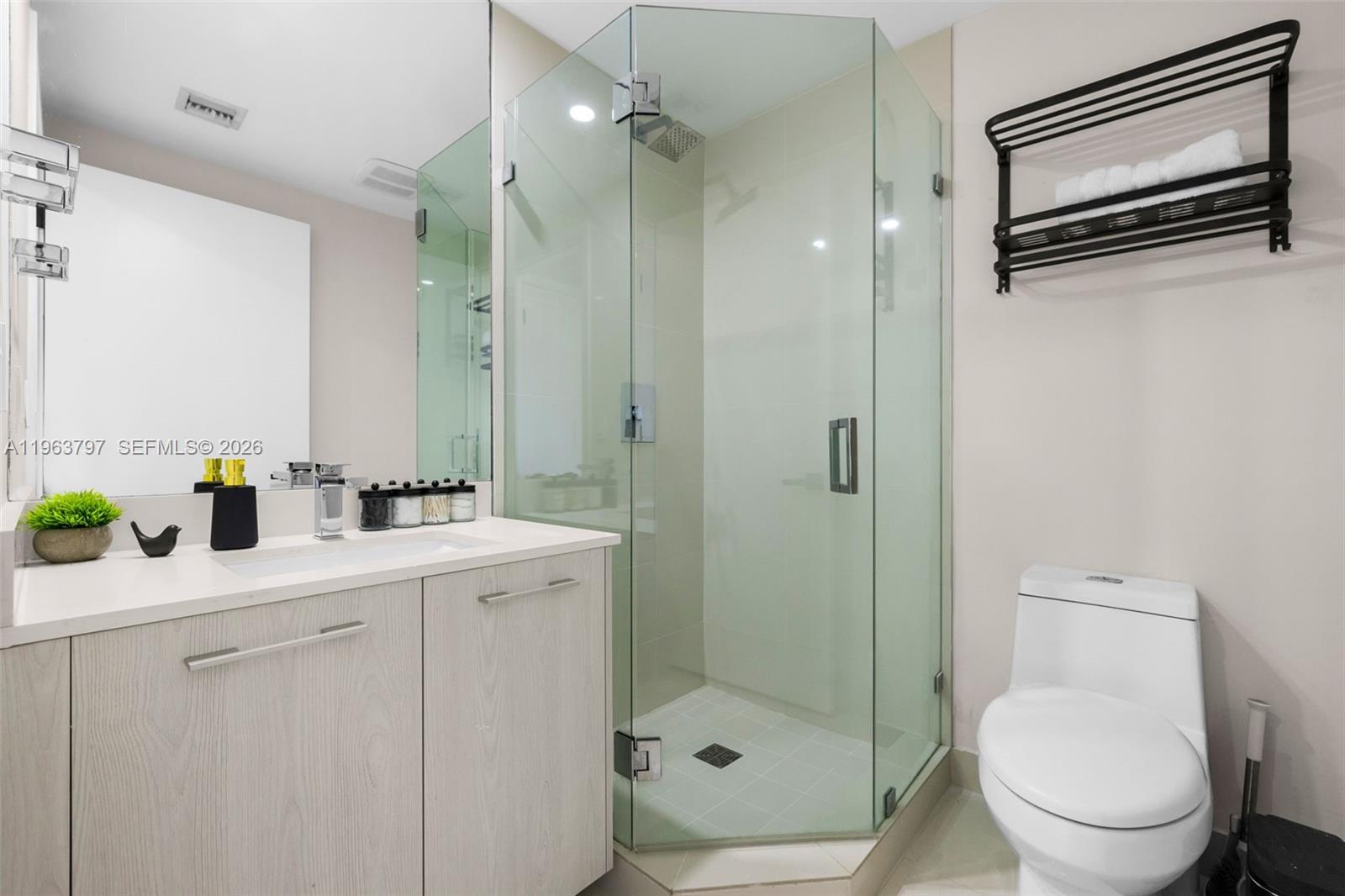 45 Southwest 9th Street, Unit 2803 Miami, FL 33130 - Photo 27 of 66 a bathroom with a shower sink mirror and toilet