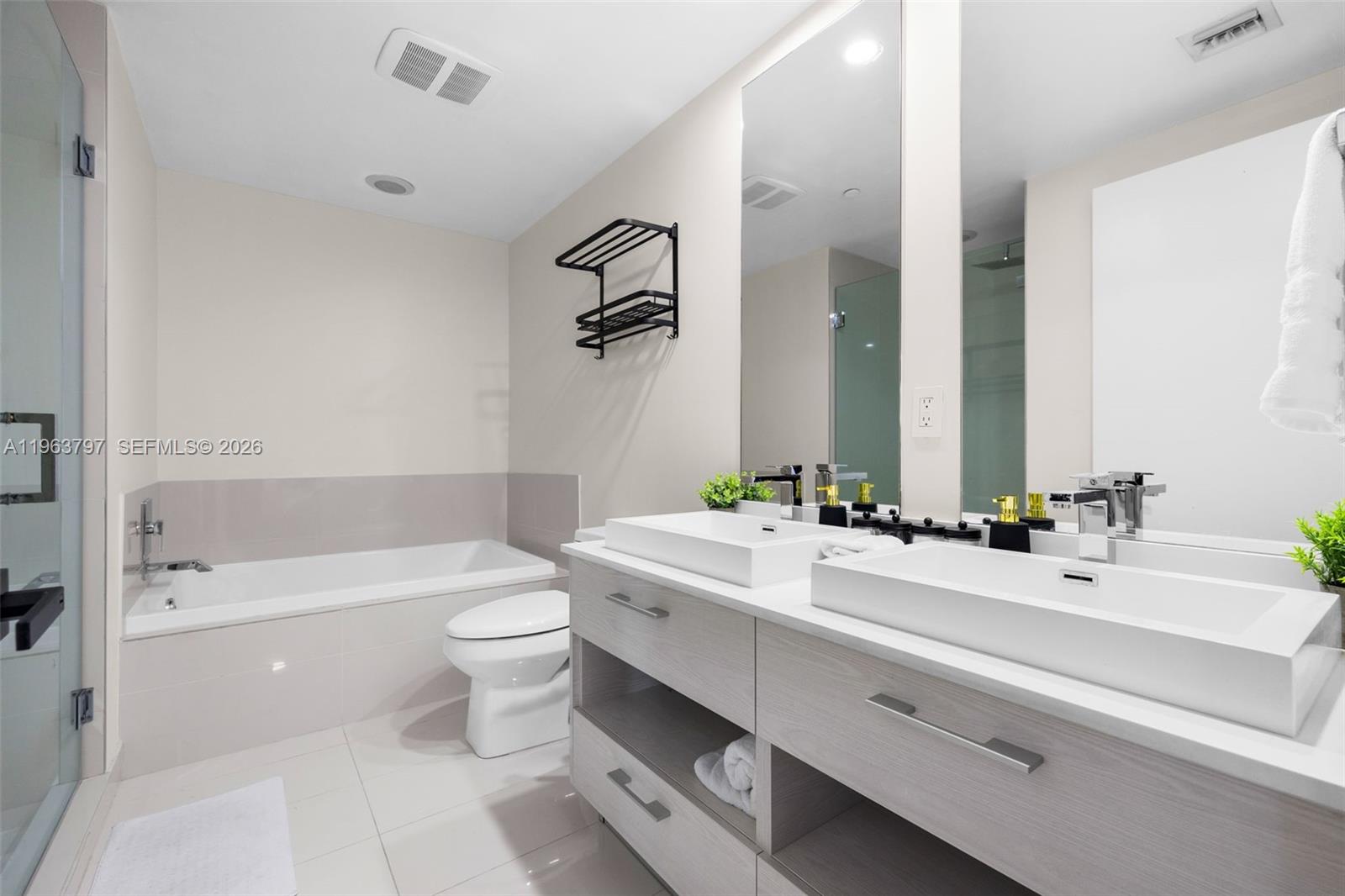 45 Southwest 9th Street, Unit 2803 Miami, FL 33130 - Photo 38 of 66 a bathroom with a double vanity sink toilet mirror and bathtub