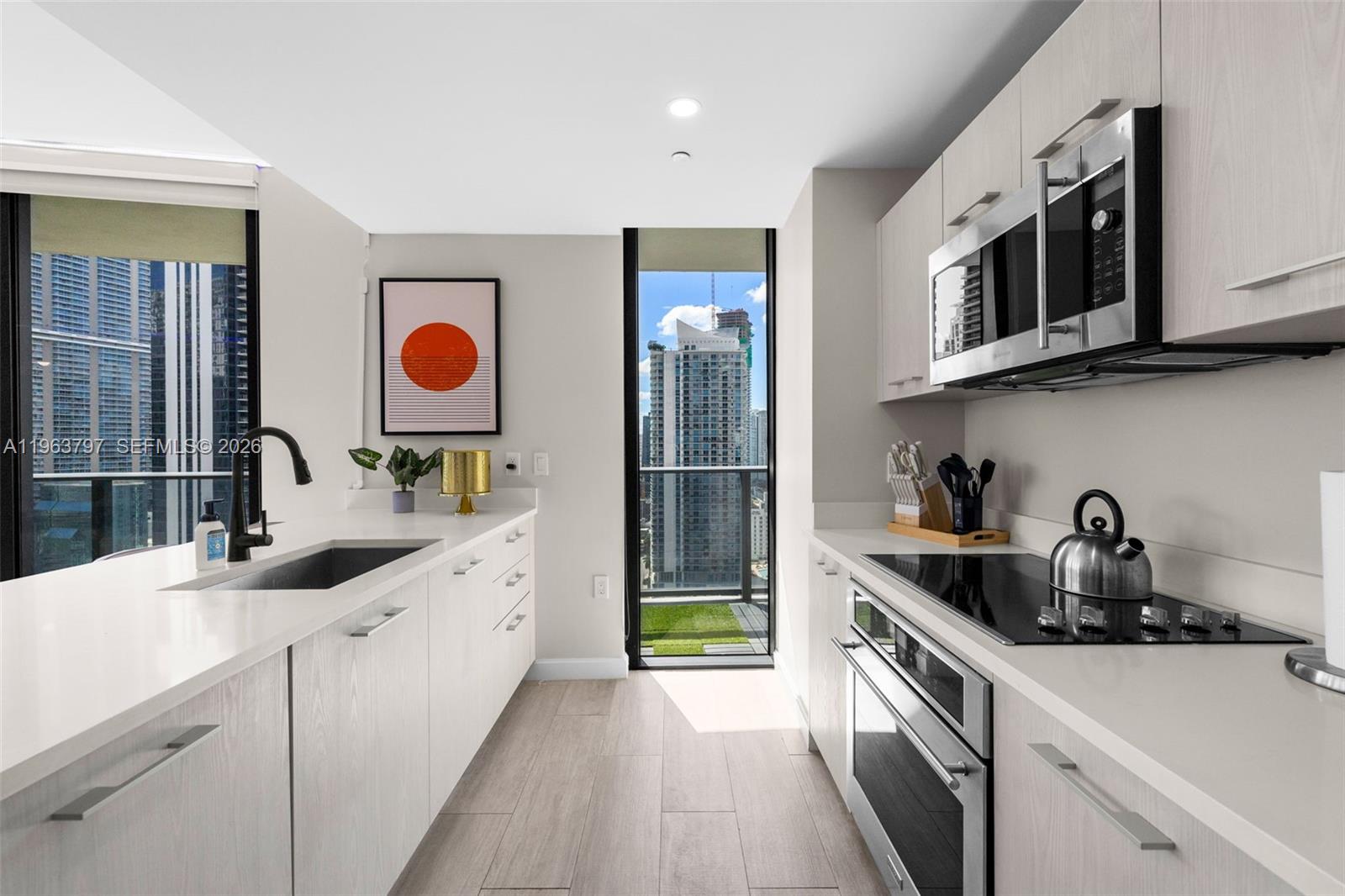 45 Southwest 9th Street, Unit 2803 Miami, FL 33130 - Photo 9 of 66 a kitchen with stainless steel appliances a sink a stove and cabinets