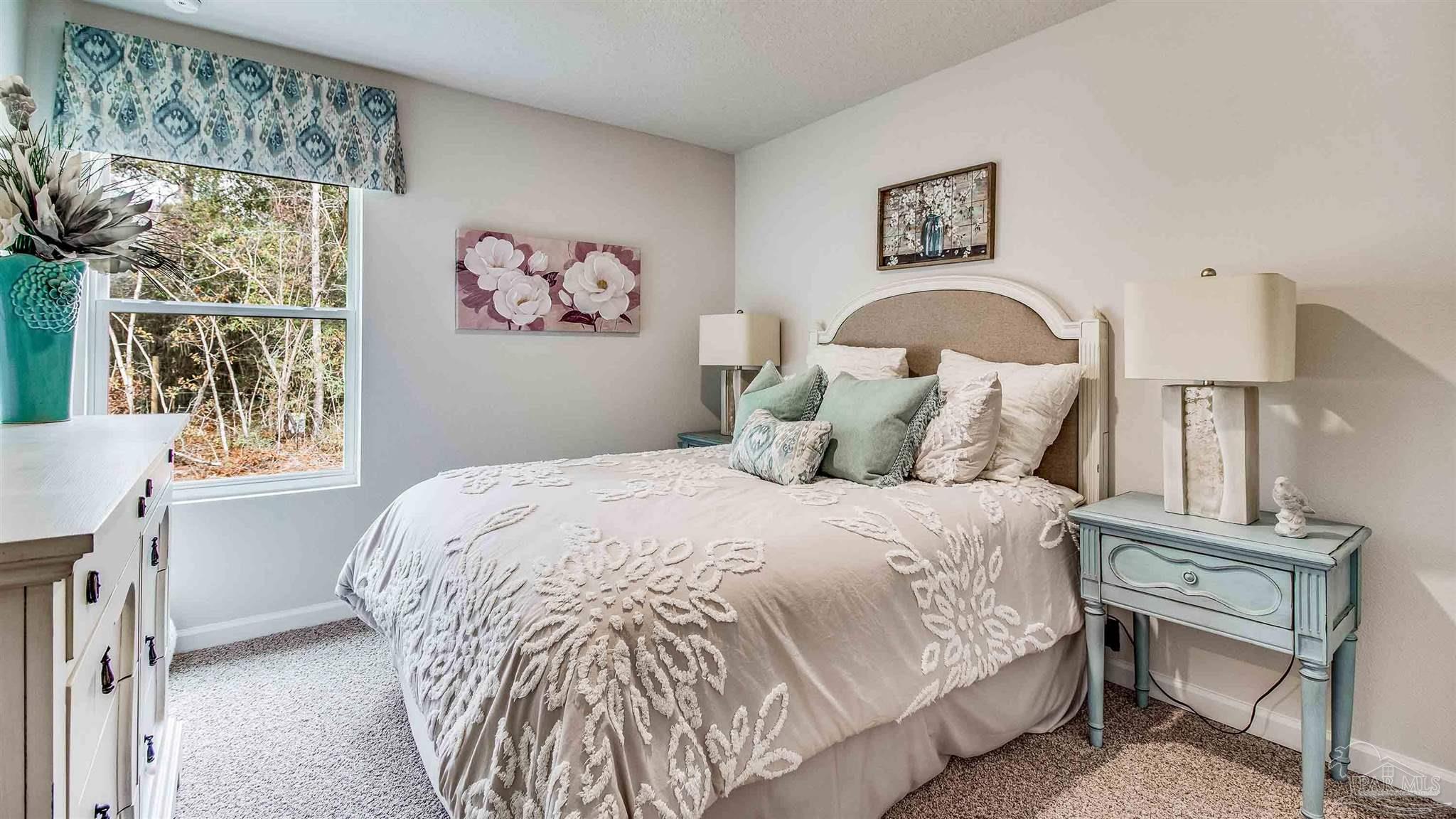 9728 Dutton Lane Milton, FL 32583 - Photo 15 of 31 a bed sitting in a bedroom next to a window