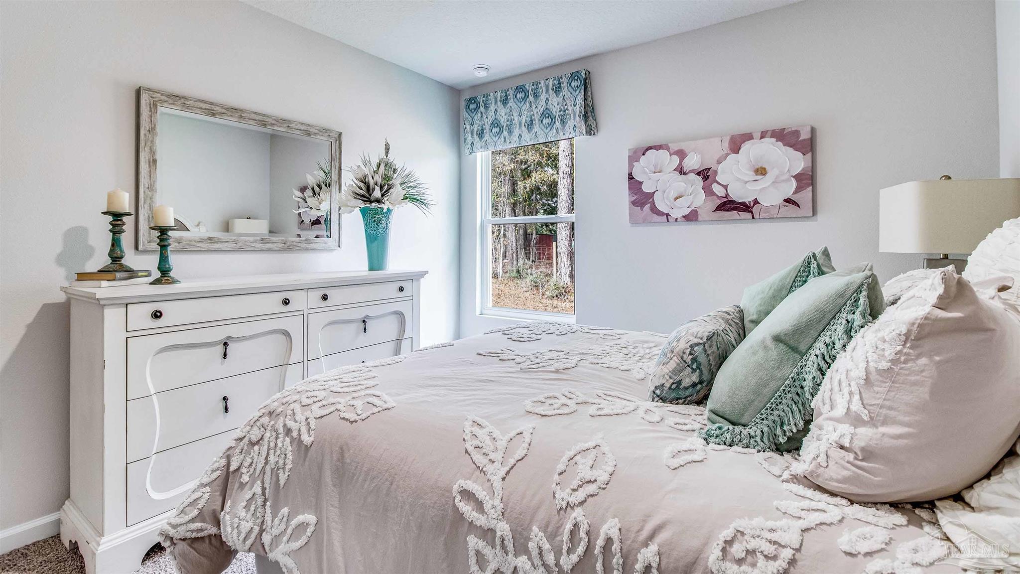 9728 Dutton Lane Milton, FL 32583 - Photo 16 of 31 a bedroom with a large bed and a mirror