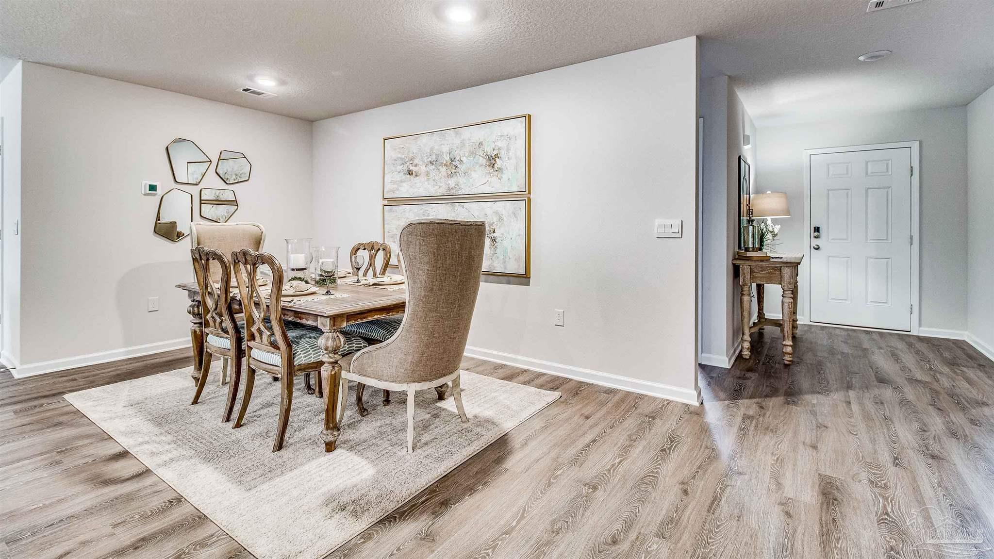 9728 Dutton Lane Milton, FL 32583 - Photo 3 of 31 a view of a dining room with furniture and wooden floor