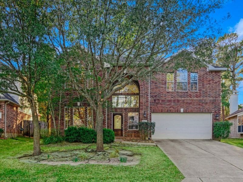 a front view of a house with a yard and trees