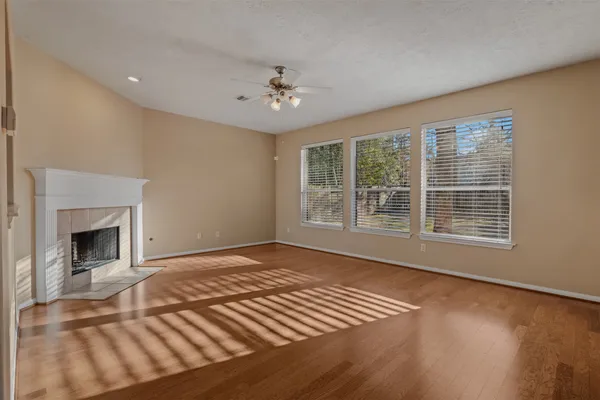 a view of an empty room with a fireplace and a window