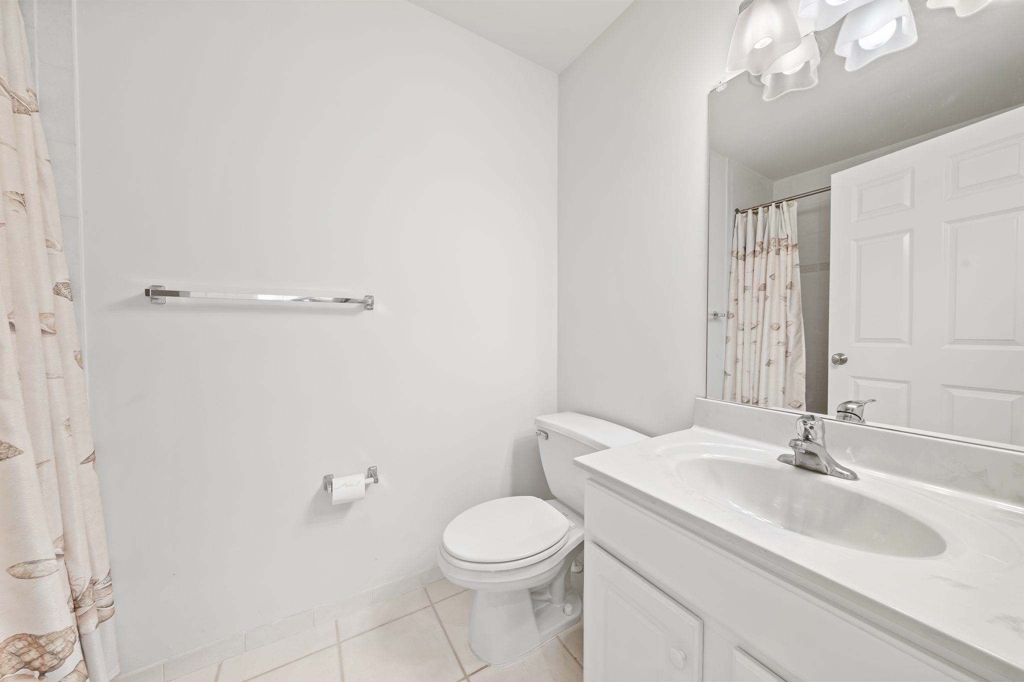 700 Ocean Drive, Unit E4 Avalon, NJ 08202 - Photo 20 of 31 a bathroom with a toilet a sink a mirror and vanity