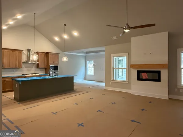 a large kitchen with kitchen island a sink stainless steel appliances and a fireplace