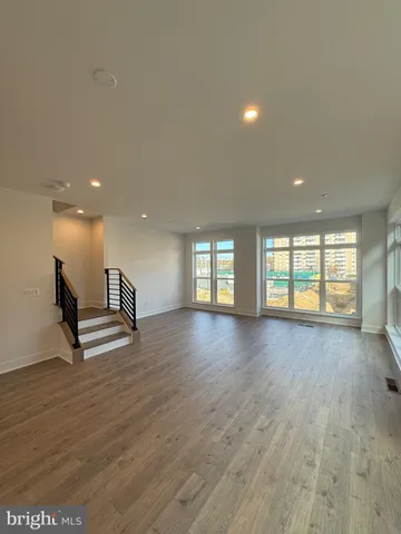 a view of empty room with wooden floor and window