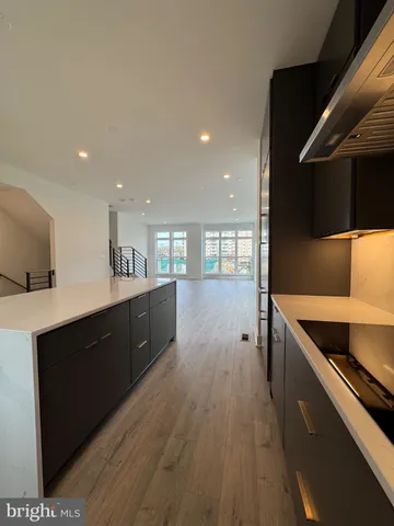 a kitchen with stainless steel appliances granite countertop a sink a stove and a wooden floors