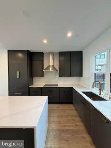 a large kitchen with granite countertop a sink and cabinets