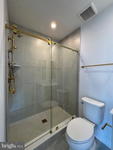 a bathroom with a shower a toilet and a shower