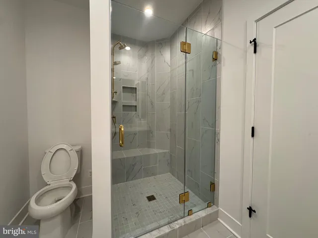 a bathroom with a shower a toilet and sink