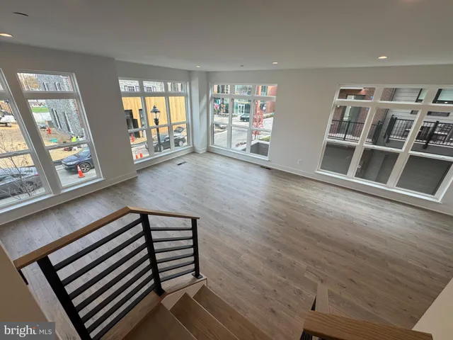 a view of an empty room with furniture and staircase