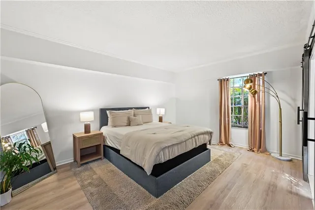 a bedroom with a large bed and a potted plant