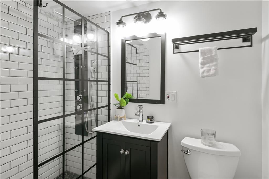 3648 Peachtree Road Northeast, Unit 1A Atlanta, GA 30319 - Photo 21 of 36 a bathroom with a shower sink and mirror