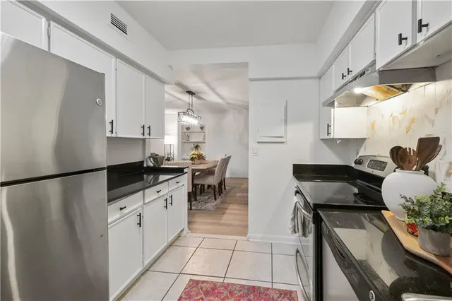 a kitchen with granite countertop a sink appliances and cabinets