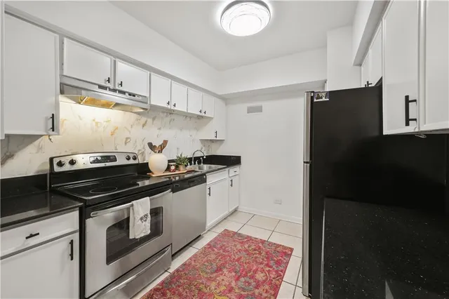 a kitchen with stainless steel appliances a sink dishwasher stove and refrigerator