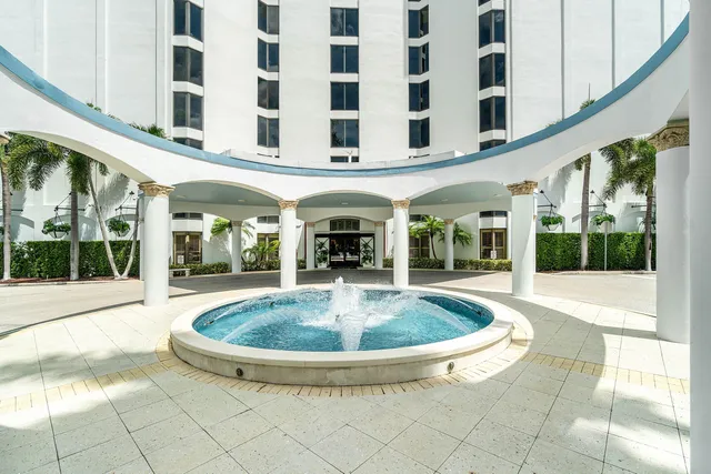 a view of white building with a swimming pool