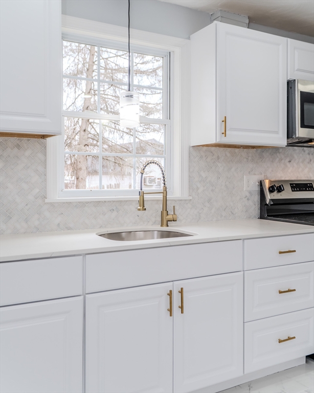 100 Pine Street Ludlow, MA 01056 - Photo 12 of 29 a kitchen with granite countertop white cabinets and a window