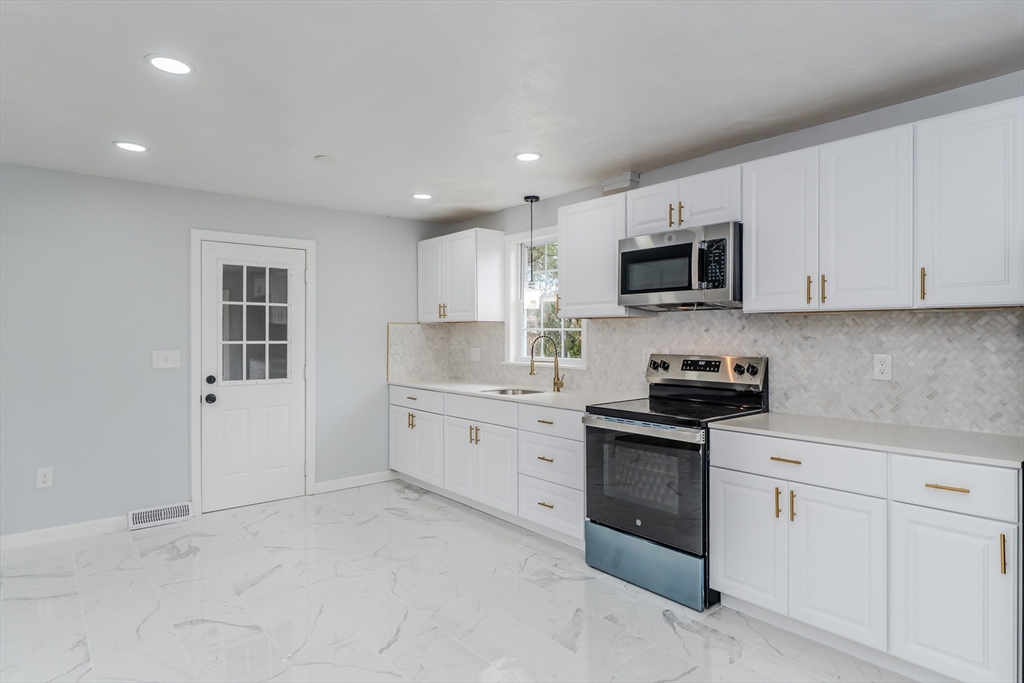 100 Pine Street Ludlow, MA 01056 - Photo 10 of 29 a kitchen with granite countertop white cabinets and white appliances