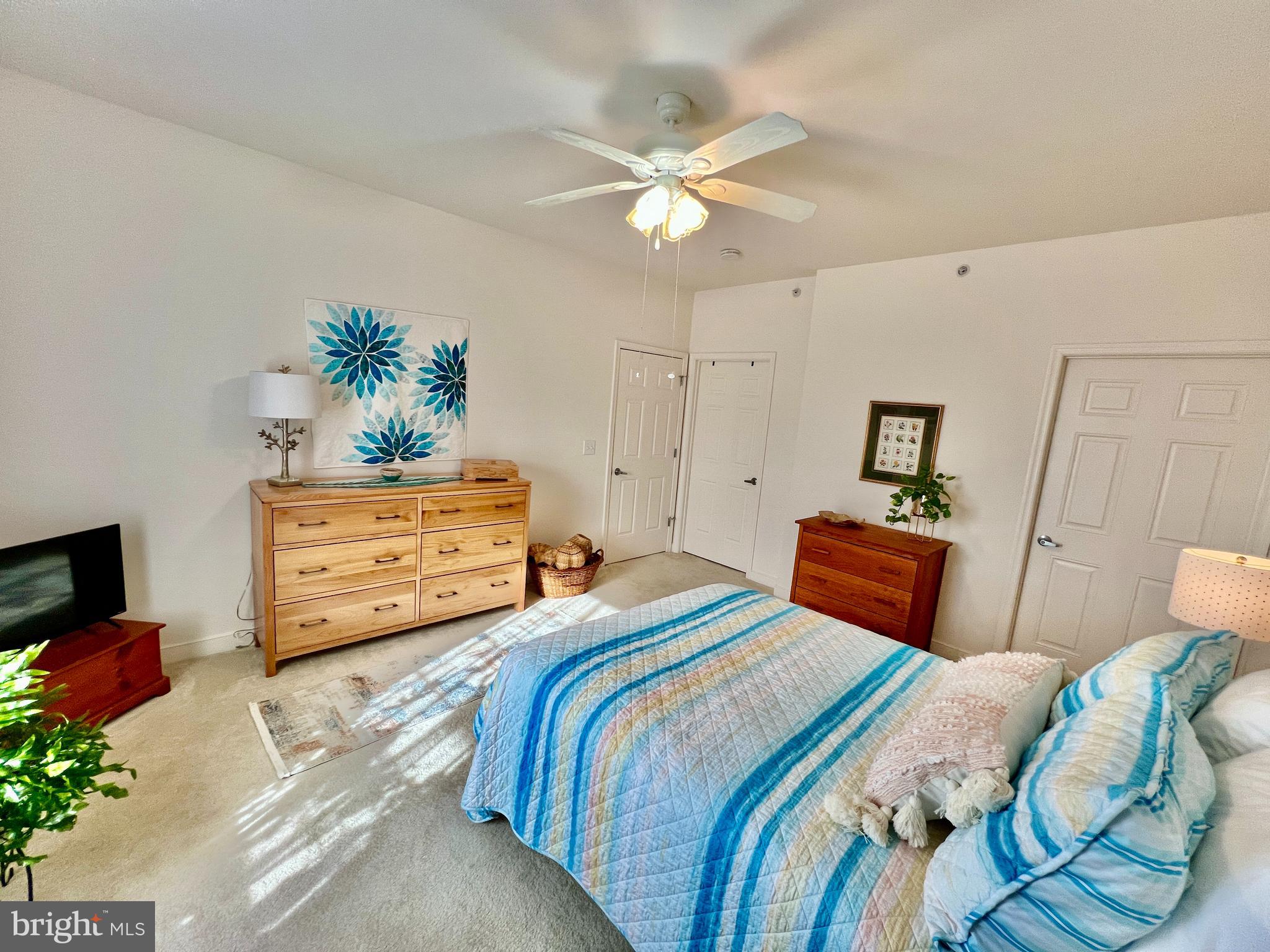 30611 Cedar Neck Road, Unit 2306 Ocean View, DE 19970 - Photo 13 of 37 a bedroom with a bed and a chandelier