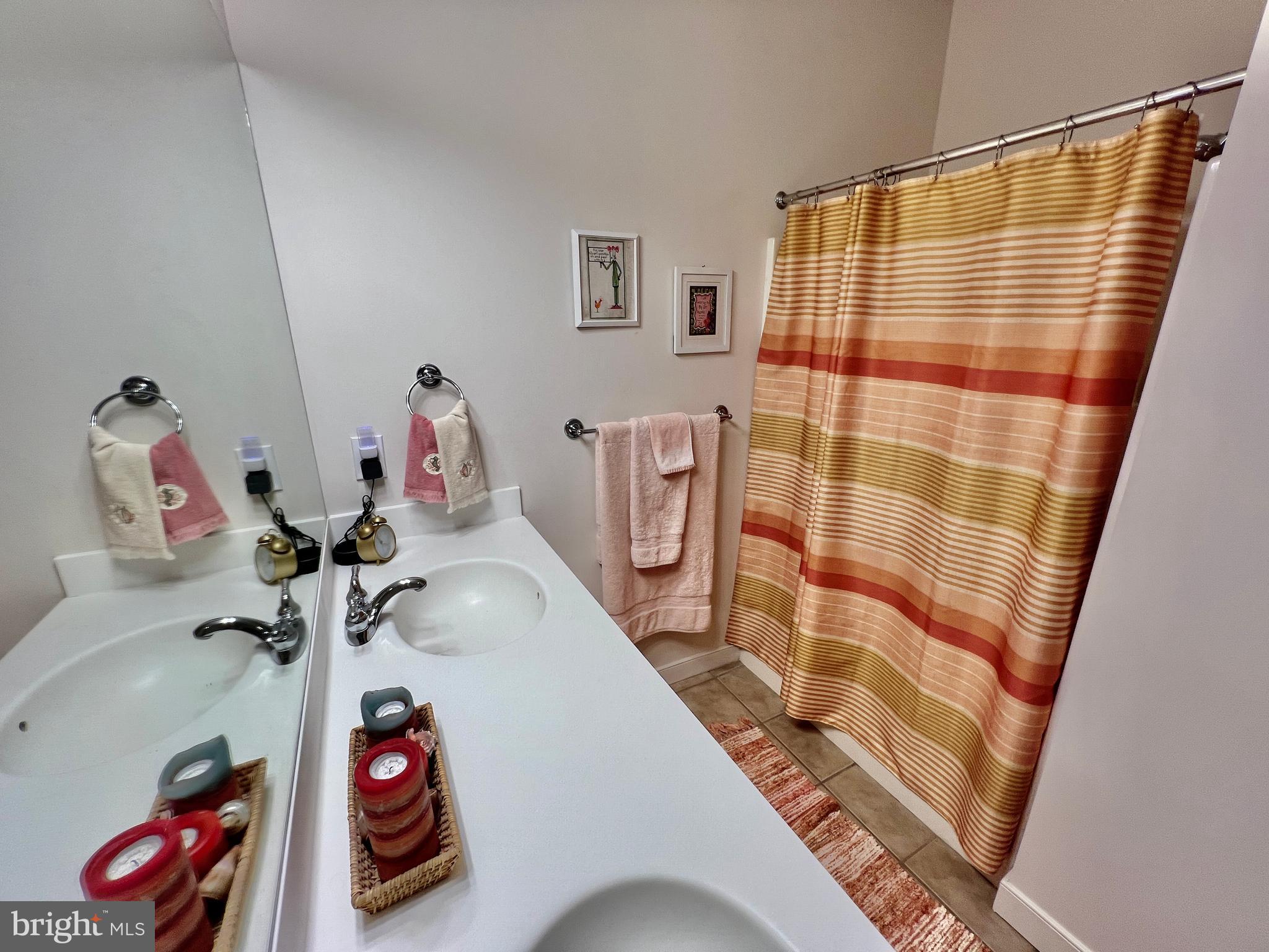 30611 Cedar Neck Road, Unit 2306 Ocean View, DE 19970 - Photo 19 of 37 a bathroom with a sink and a shower curtain