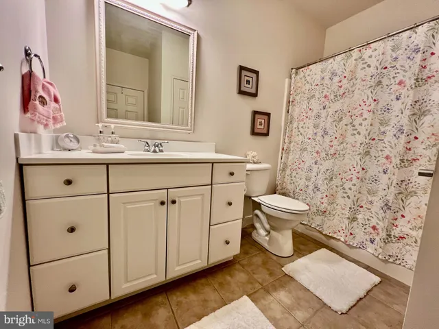 a view of a patio with table and chairs potted plants and floor to ceiling window