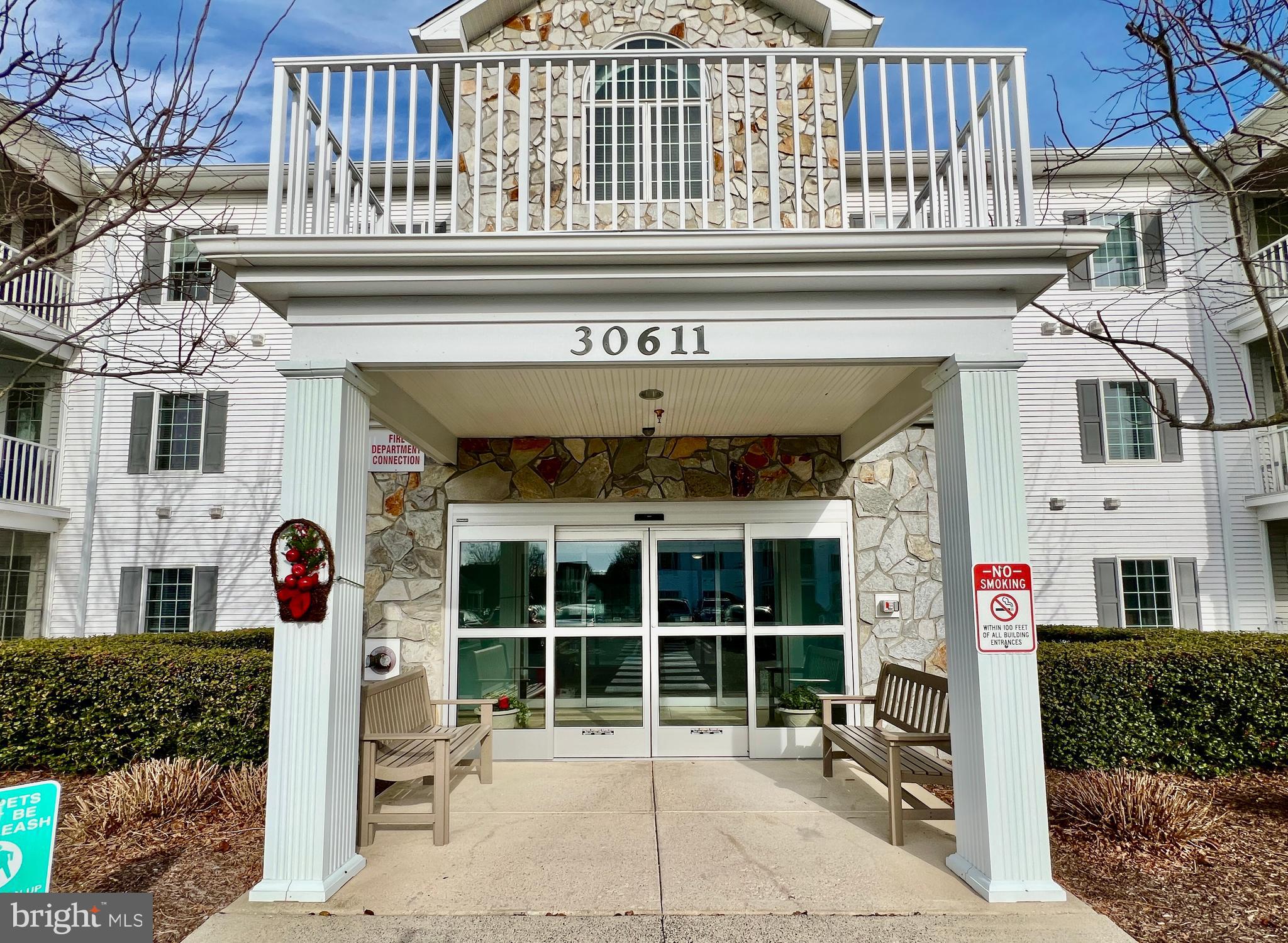 30611 Cedar Neck Road, Unit 2306 Ocean View, DE 19970 - Photo 34 of 37 a front view of a building with a porch