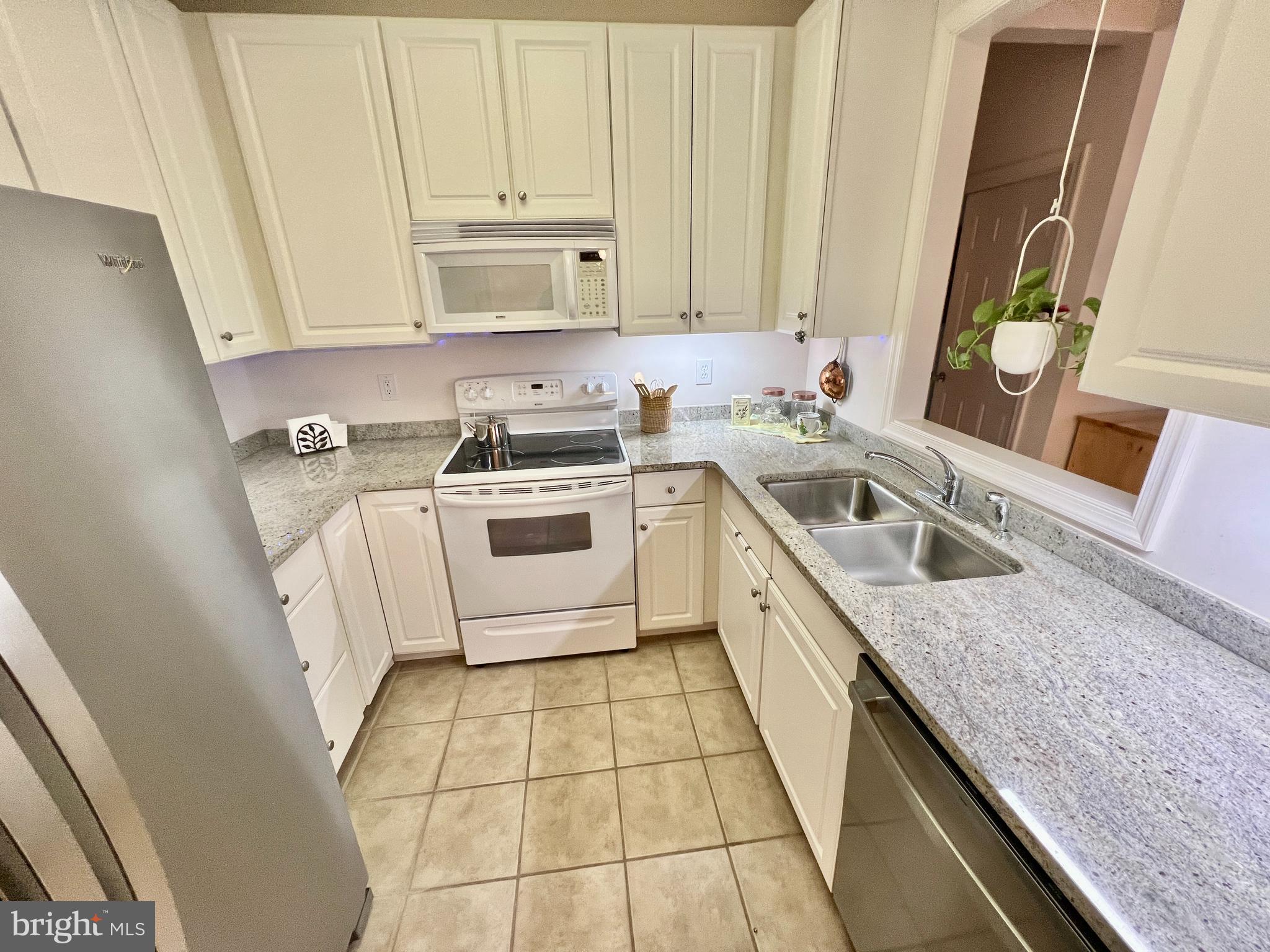 30611 Cedar Neck Road, Unit 2306 Ocean View, DE 19970 - Photo 8 of 37 a kitchen with a sink stove and cabinets