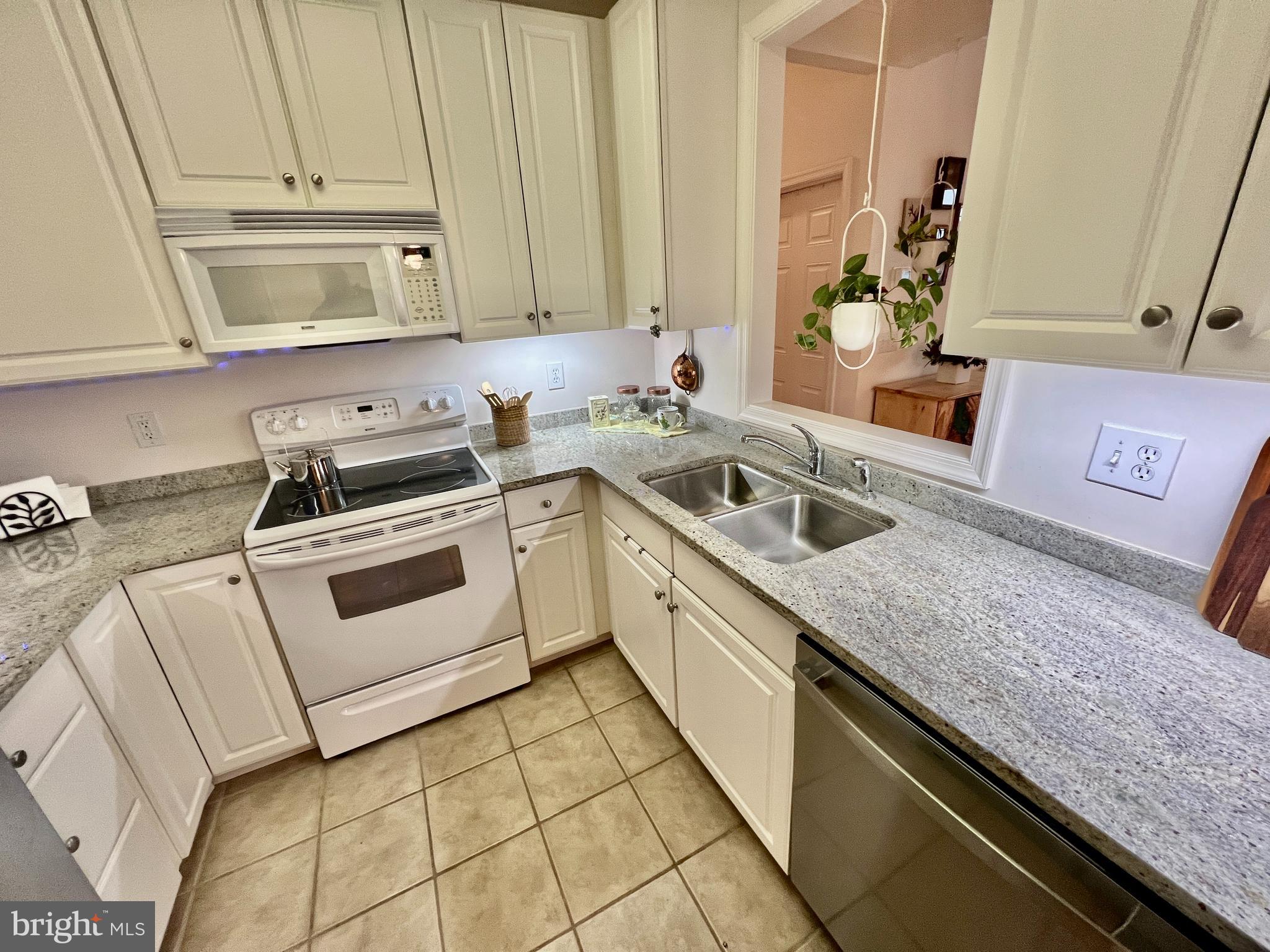 30611 Cedar Neck Road, Unit 2306 Ocean View, DE 19970 - Photo 10 of 37 a kitchen with granite countertop a sink a stove and cabinets
