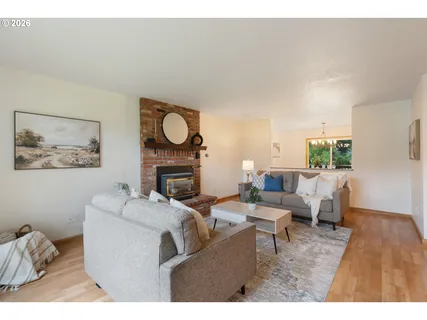 a living room with furniture a fireplace and a large window