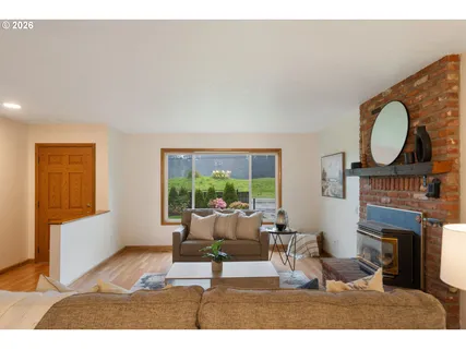 a living room with furniture a fireplace and a large window