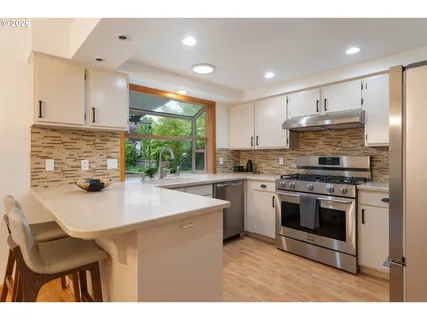 a kitchen with kitchen island a stove a counter space and a sink