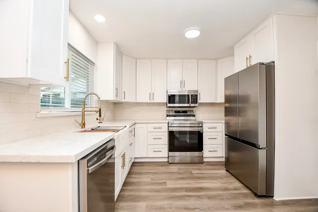 a kitchen with a refrigerator stove and sink