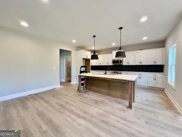 a view of kitchen with refrigerator stove and wooden floor