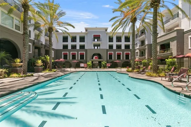 a view of building with swimming pool and chairs