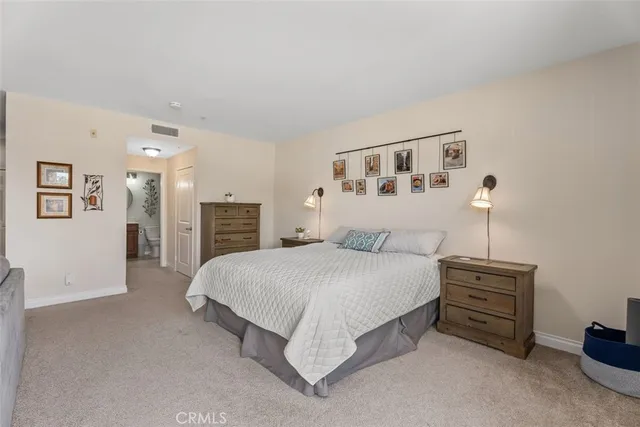 a spacious bedroom with a bed and a cabinets