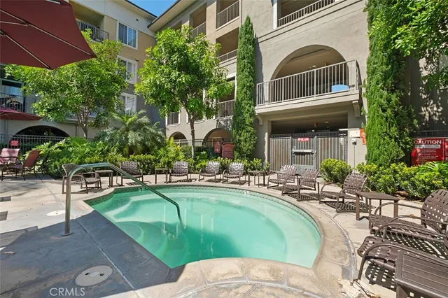 a view of a swimming pool with chairs and plants