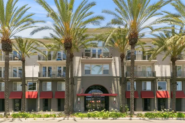 a front view of multi story residential apartment building with yard and parking space