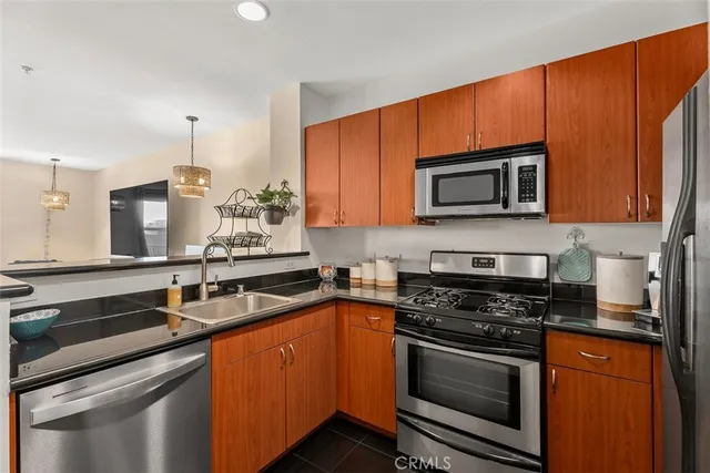 a kitchen with stainless steel appliances a stove microwave and sink