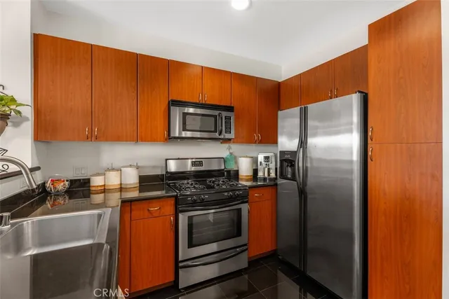 a kitchen with stainless steel appliances granite countertop a refrigerator stove and microwave