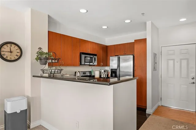 a kitchen with stainless steel appliances a refrigerator and microwave