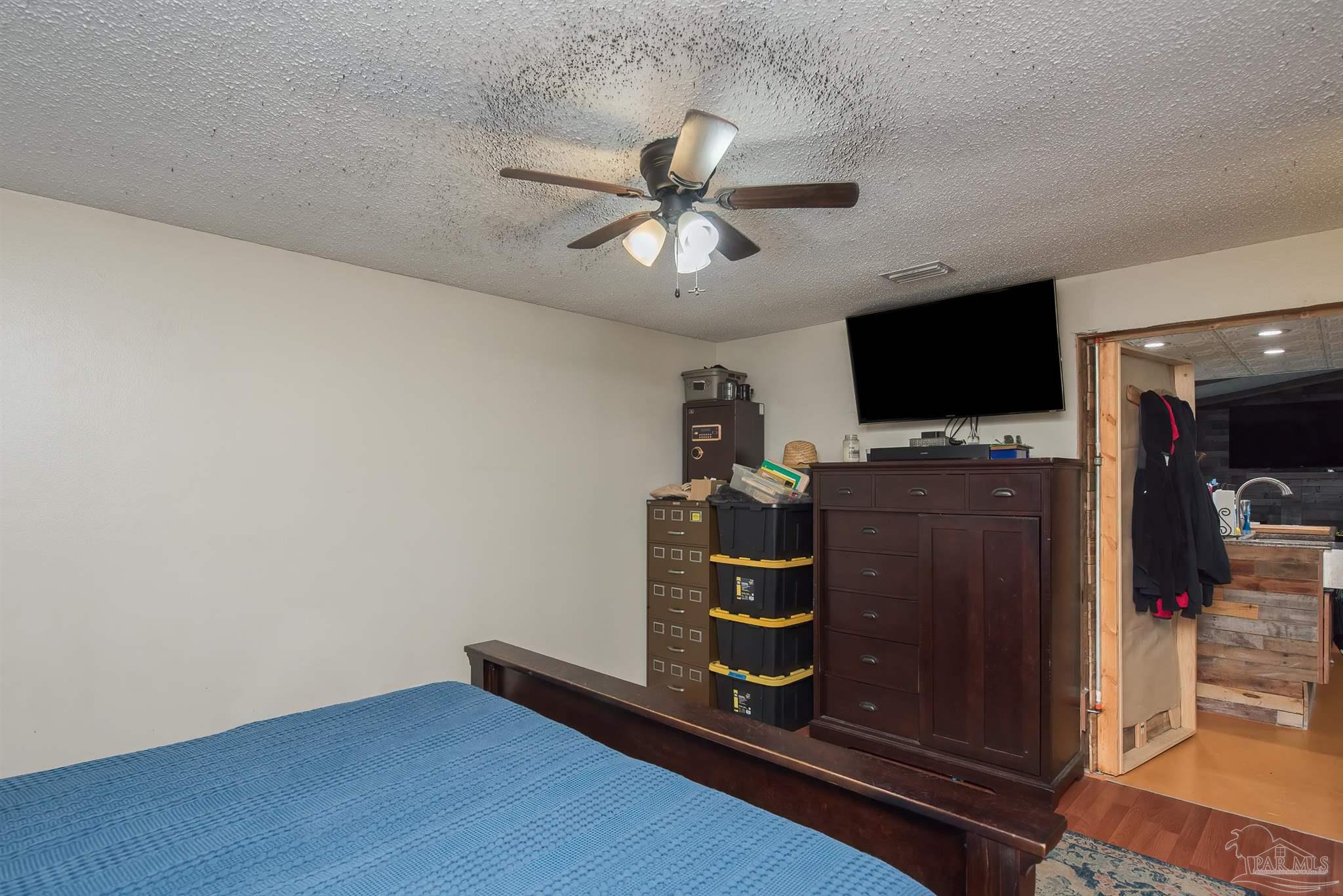 2322 Silversides Loop Pensacola, FL 32526 - Photo 12 of 29 a view of a livingroom with a flat screen tv wooden floor and a chandelier fan